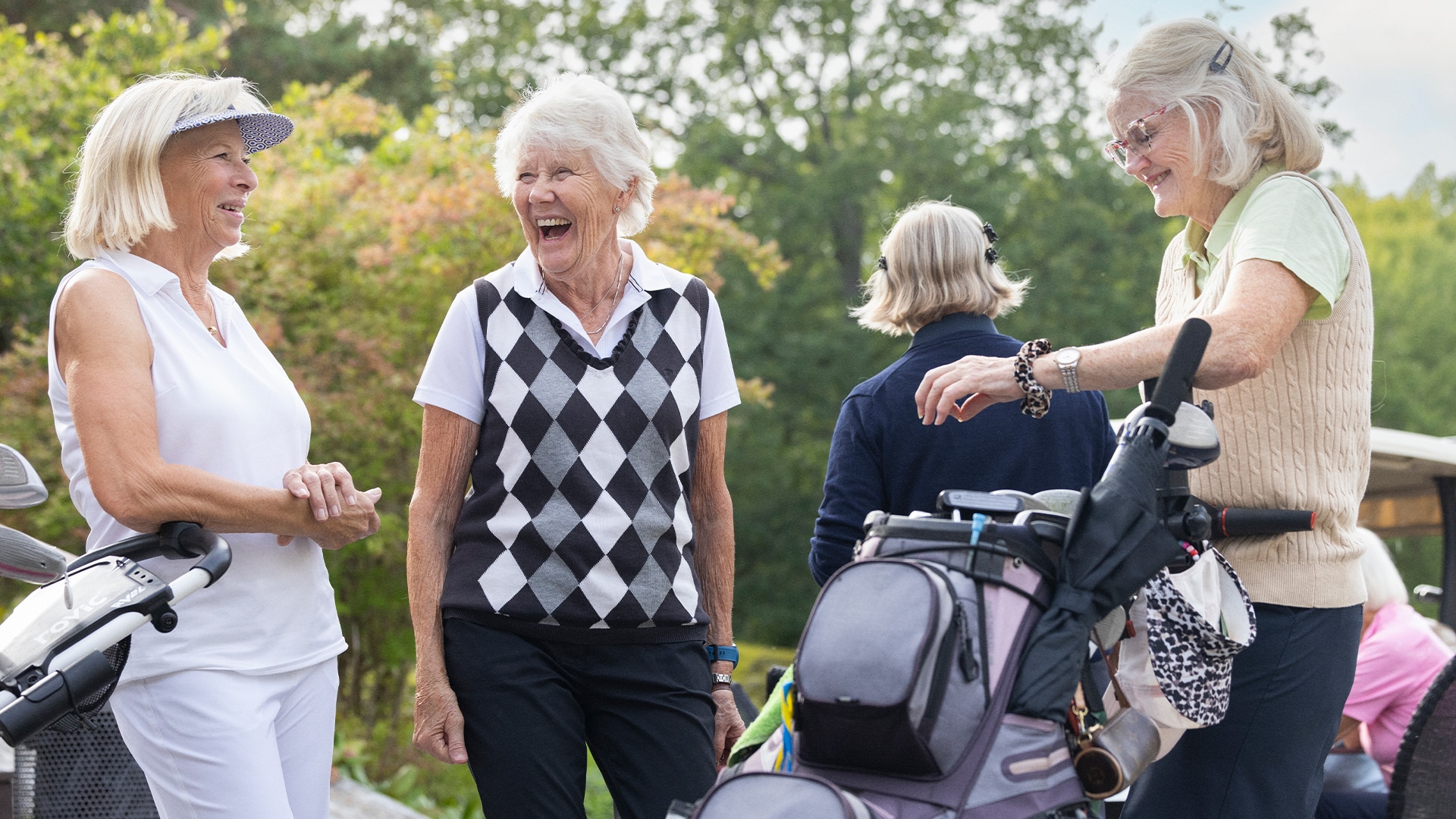 Tre glada kvinnor, 65+, inför en golfrond.